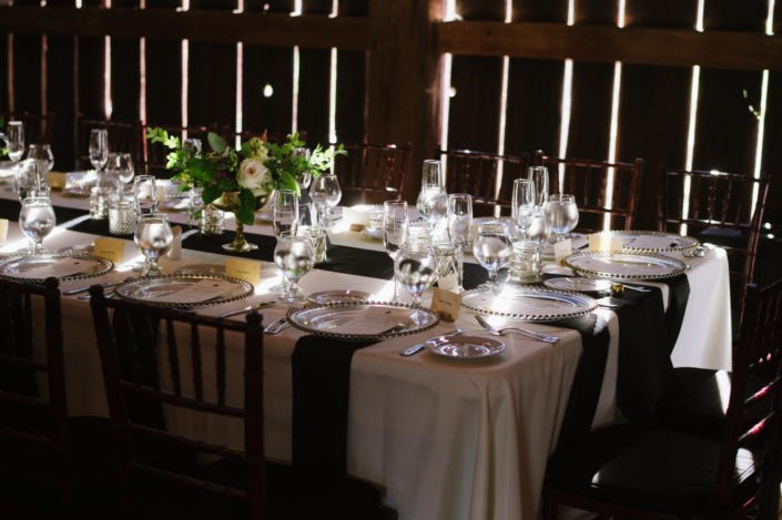 Close up of a wedding reception table with dramatic lighting in the Pegasus Barn.