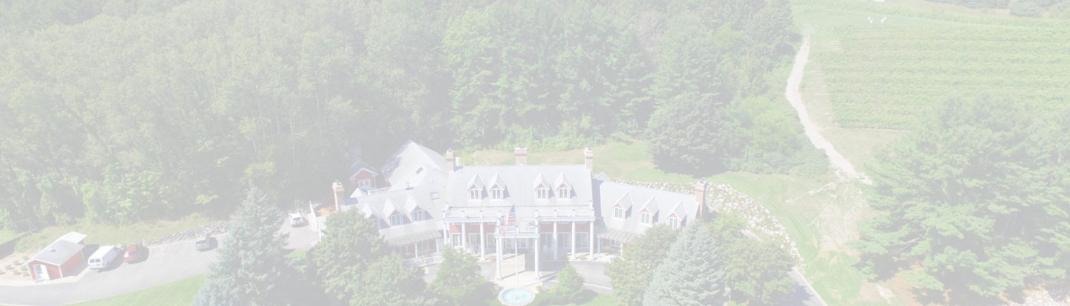 Aerial view of the Inn at Black Star Farms with surrounding forest and vineyards.