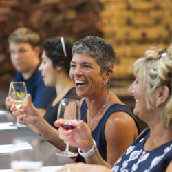 People having fun wine tasting in our Barrel Room at Black Star Farms Suttons Bay.