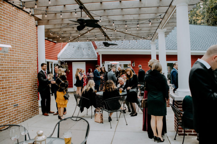 Guests enjoying a small wedding reception on the covered patio at the Inn at Black Star Farms.