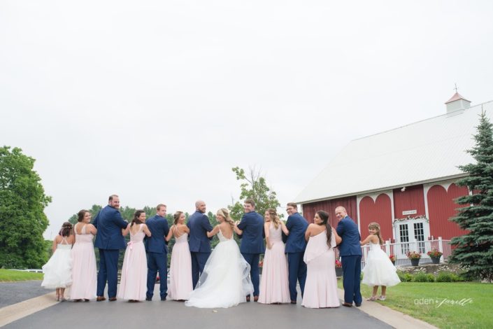 Wedding party walking down the drive and looking back at the camera in front of the Pegasus Barn.