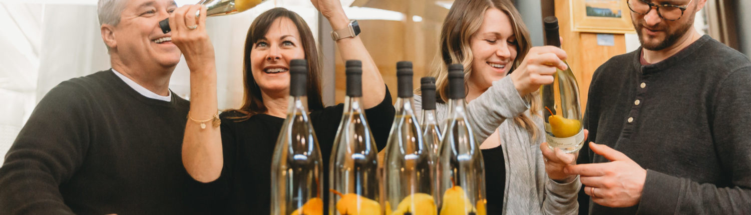 Couples looking at our Pear and its Spirit at the tasting room at Black Star Farms Suttons Bay. This is a pear brandy with a real pear inside the bottle.