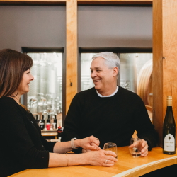 A couple wine tasting at the main bar at Black Star Farms Suttons Bay.