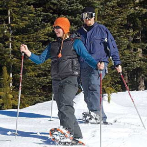 Couple snowshoeing in the woods.