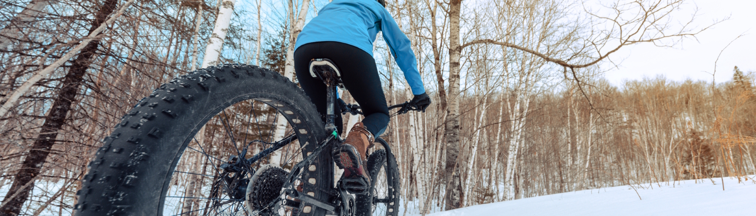 Woman fat tire biking in the snow.