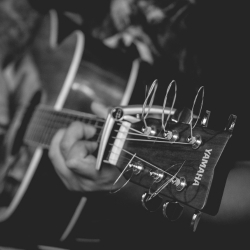 Close up of person playing a guitar.