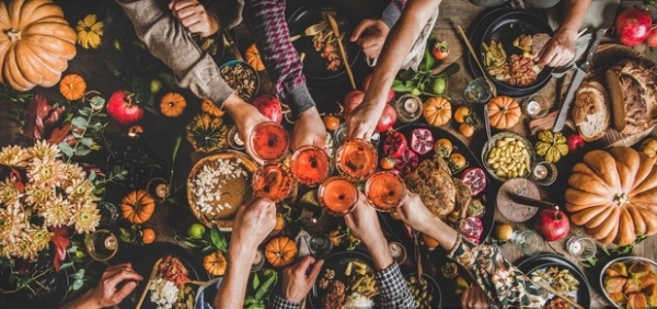 friendsgiving Group of people toasting wine at festive table with roast chicken squash pie wide composition bEE71b free